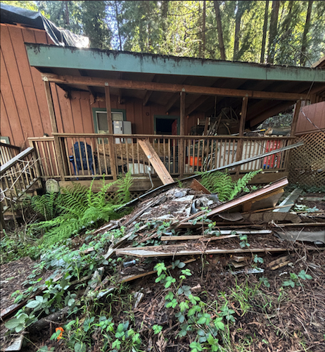 Before view of construction debris piled beside a porch